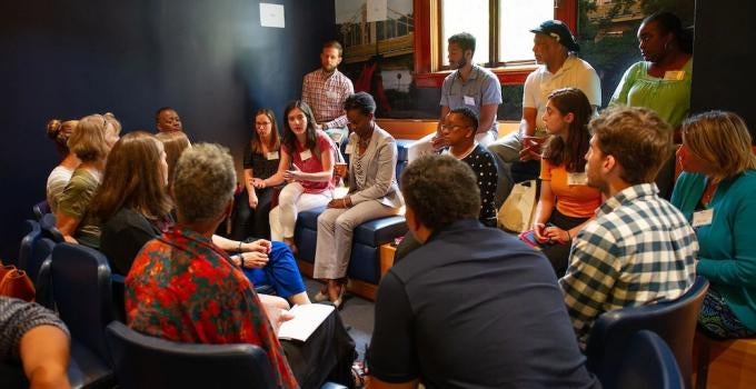 Students, faculty, and staff holding a discussion group