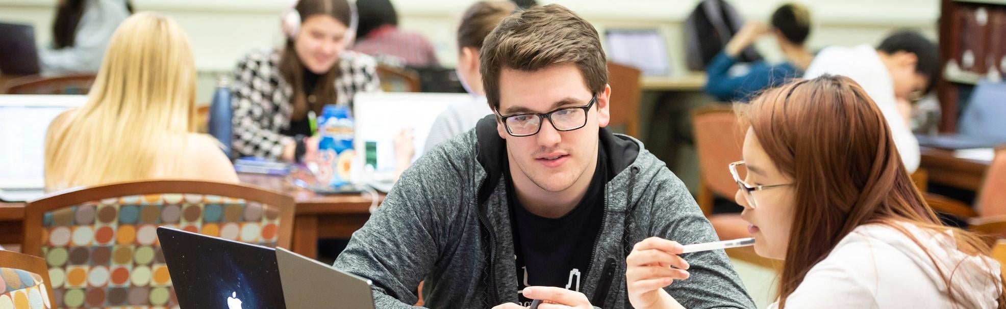 Two students in a peer mentoring program work on a project together.